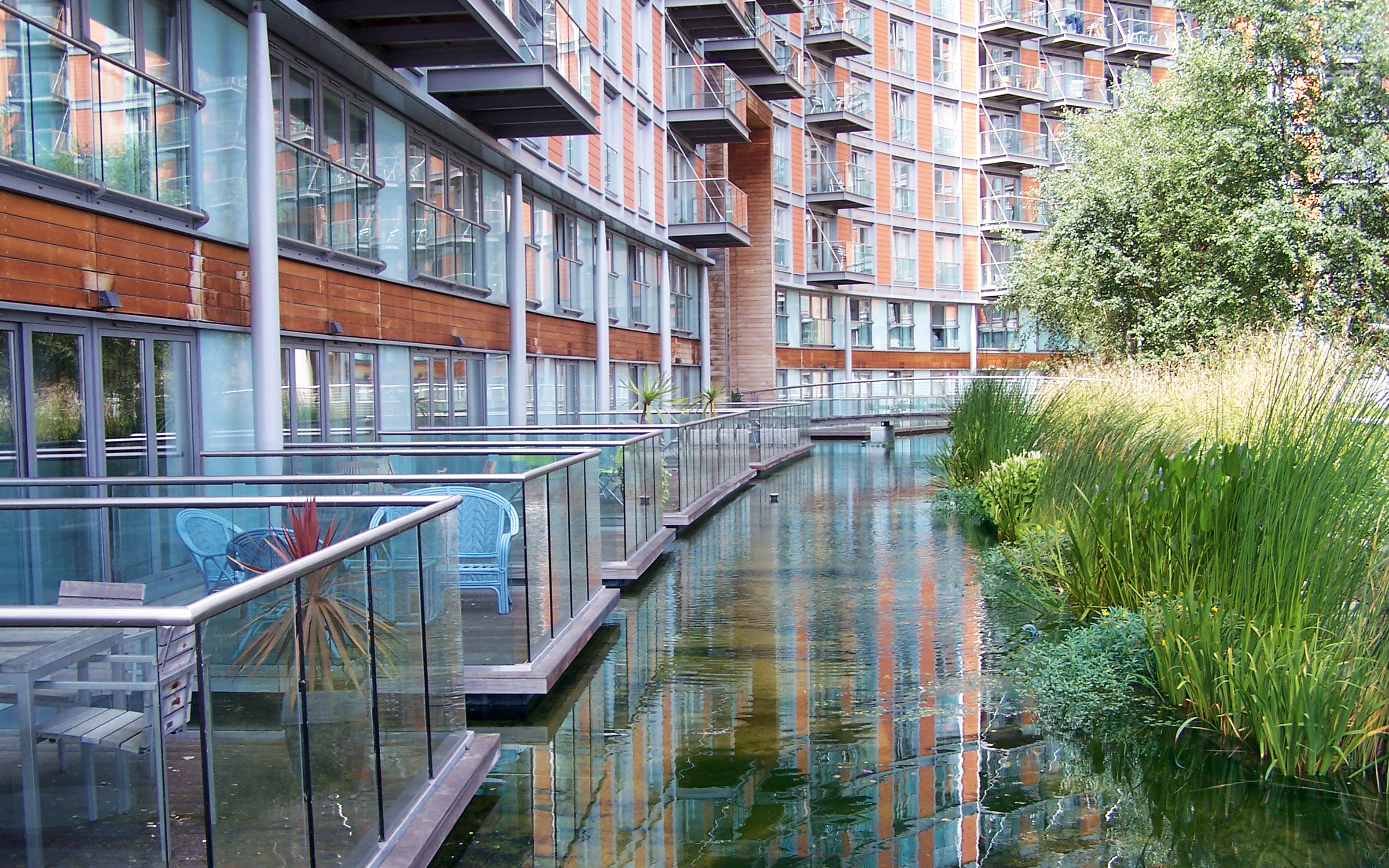 The balconies of the ground floor flats jut out over the artificial watercourse. Water course in front of balconies